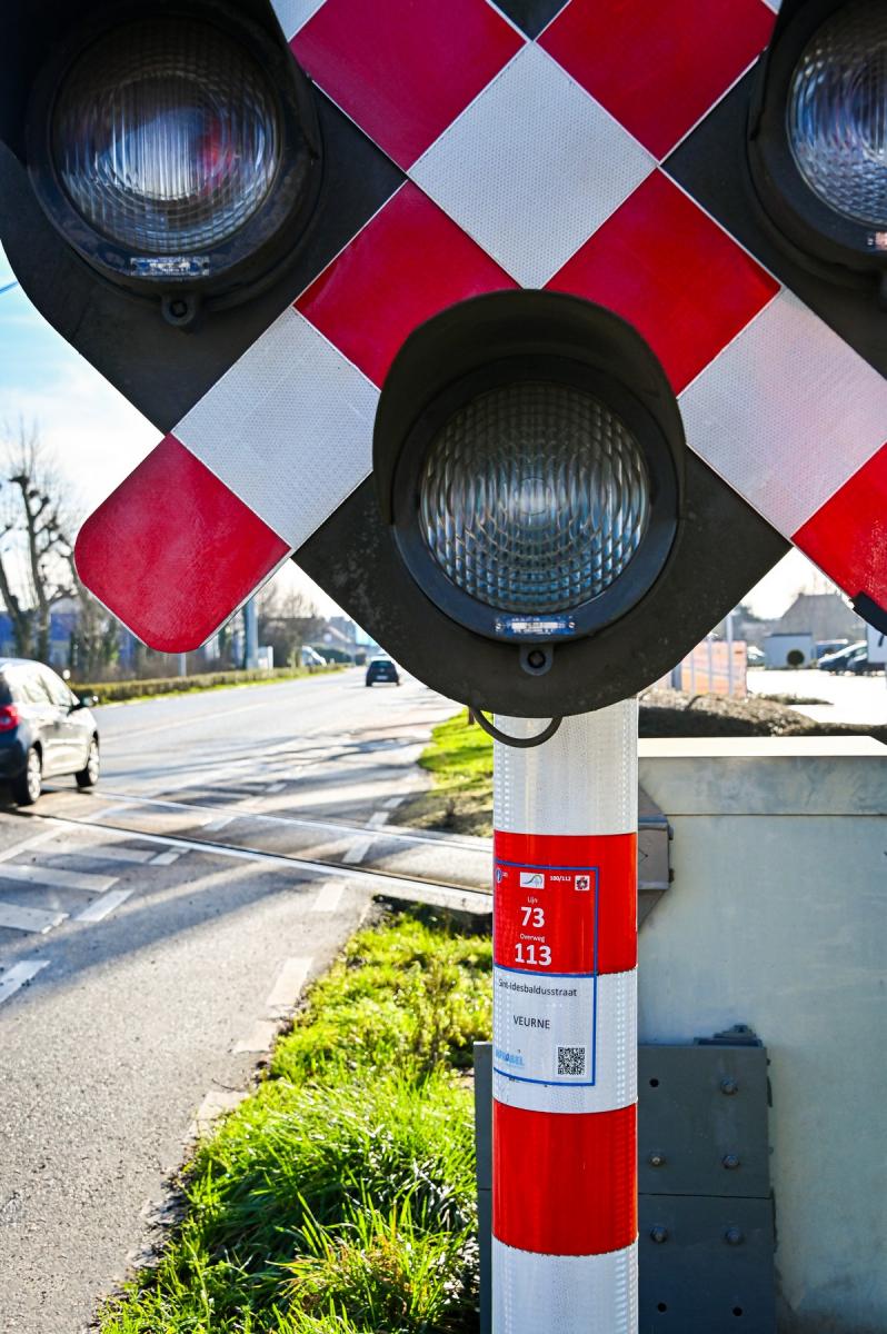 Infrabel-spooroverweg met een rode sticker