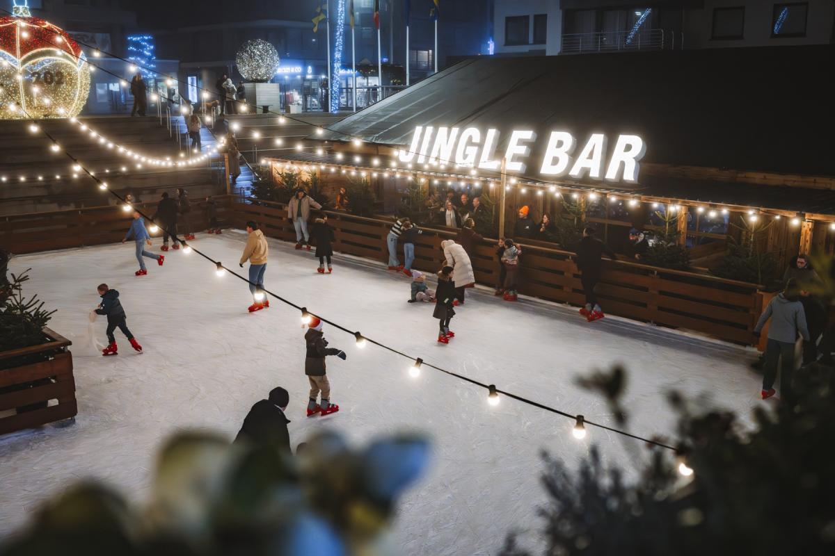 Kinderen, jongeren en volwassenen aan het schaatsen op de overdekte ijsbaan voor het gemeentehuis in Koksijde tijdens de kerstperiode