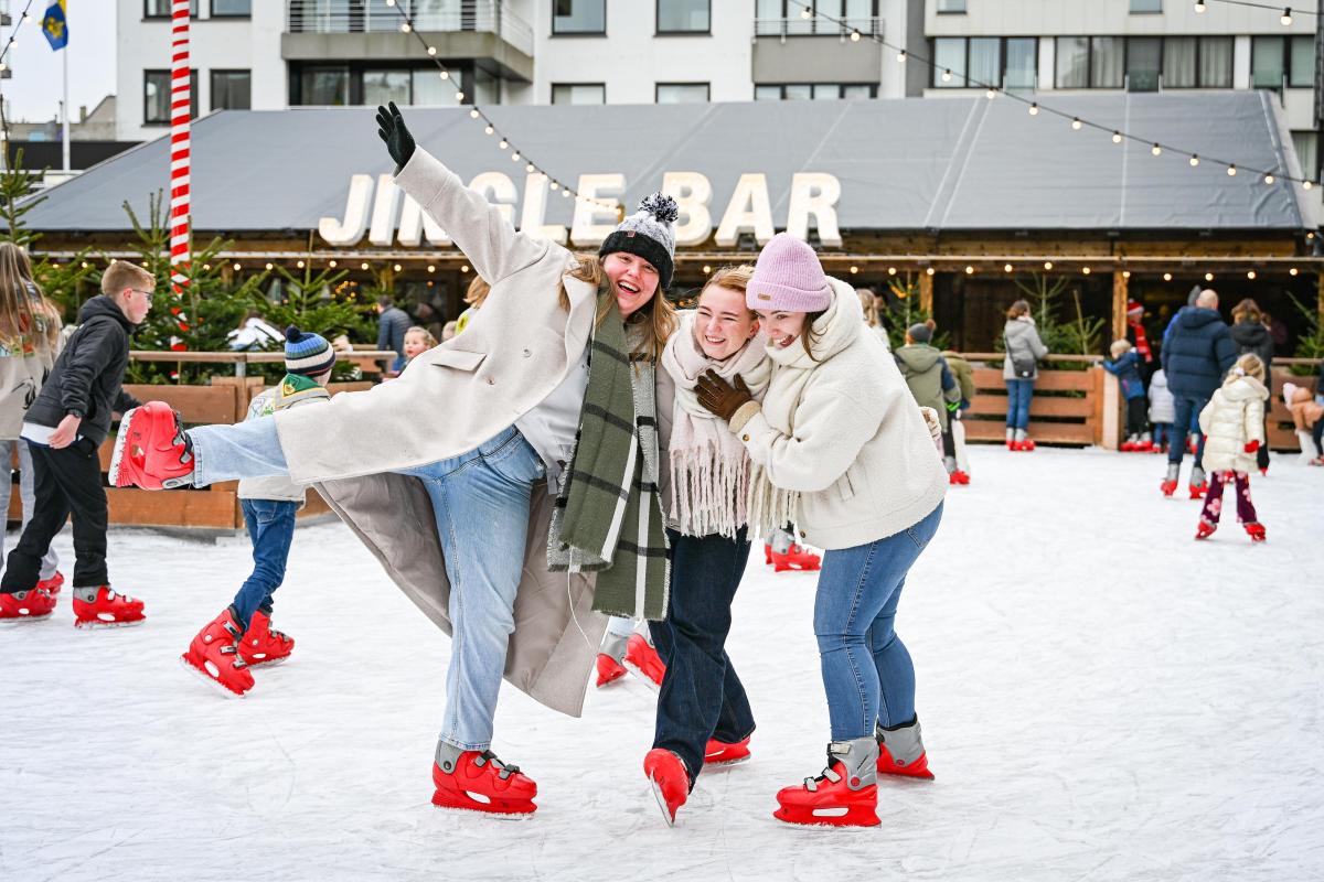 Kinderen, jongeren en volwassenen aan het schaatsen op de overdekte ijsbaan voor het gemeentehuis in Koksijde tijdens de kerstperiode